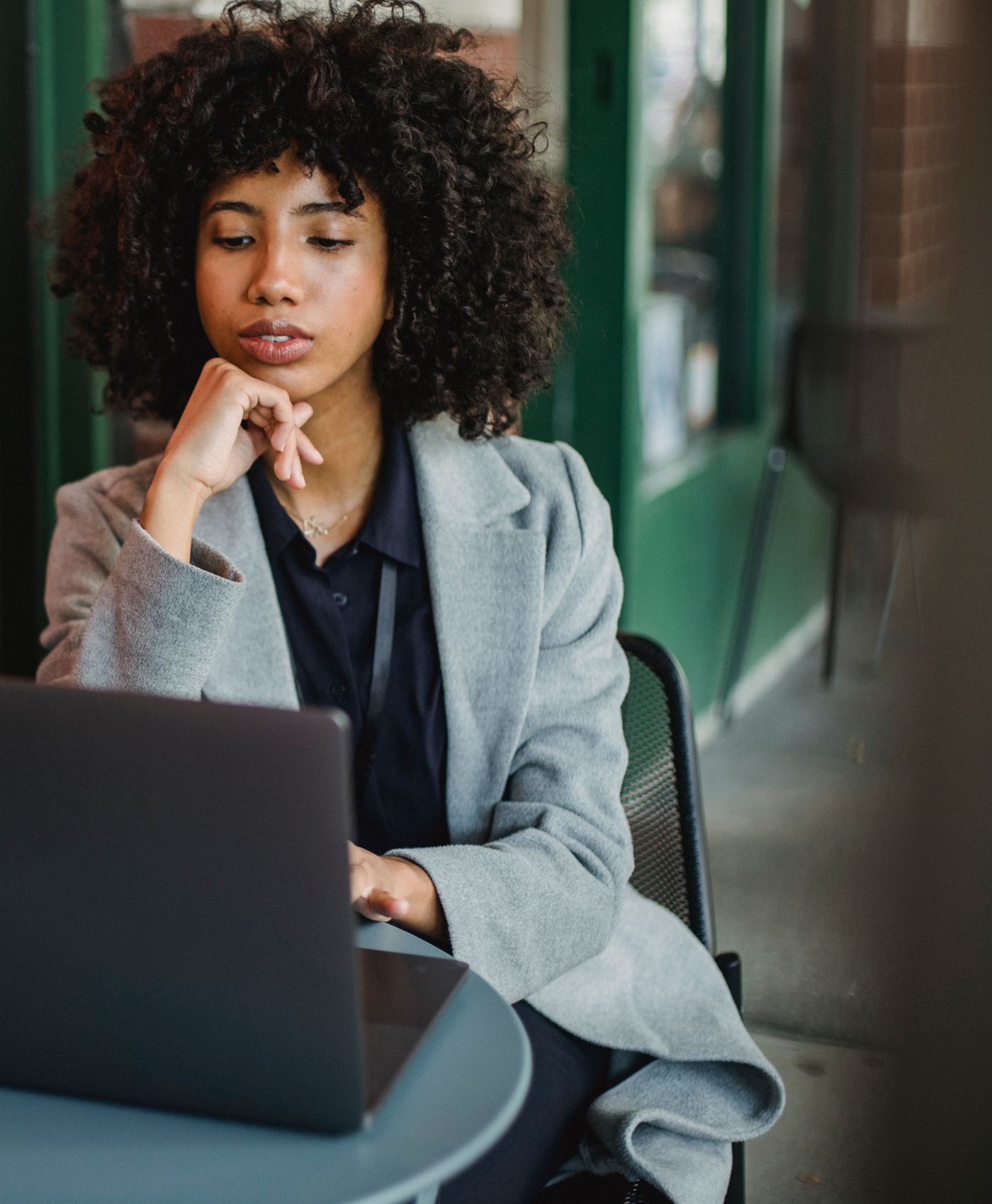 Woman working at a laptop in a café.